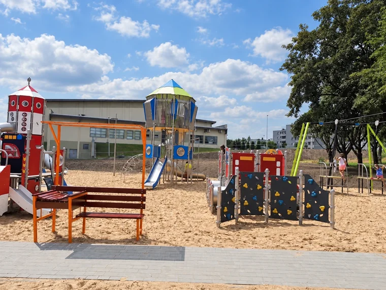 Kolorowe wieże i urządzenia zabawowe na piaszczystym placu zabaw