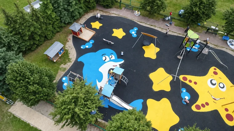 Plac zabaw z delfinem i rozgwiazdami wśród drzew